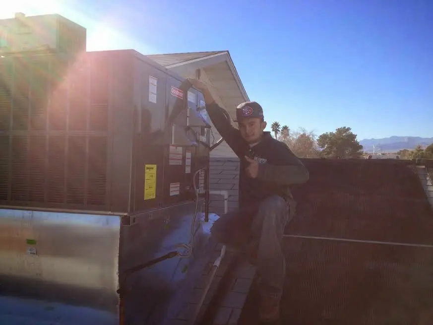 HVAC technician performing Air Duct Cleaning on a rooftop unit in Eunice